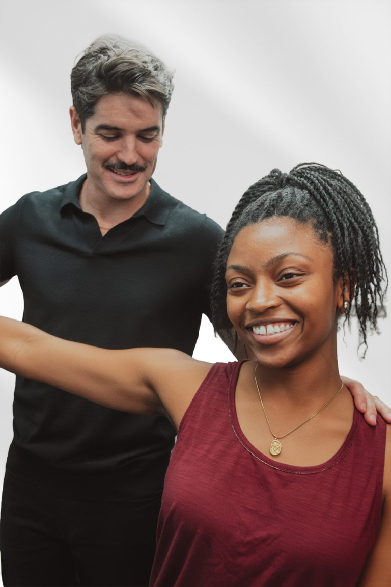 Physical therapist assisting a patient with shoulder mobility and rehabilitation exercises during a one-on-one physical therapy session.