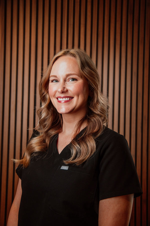 Smiling female healthcare professional in black medical uniform